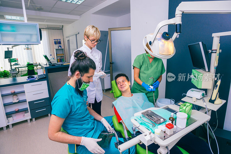 牙医团队向小男孩病人解释x光扫描图