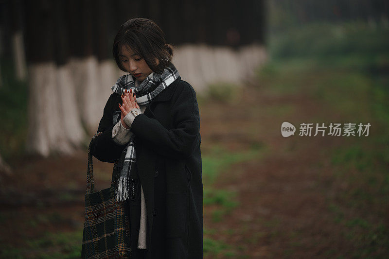 亚洲女孩走在河边的雨天