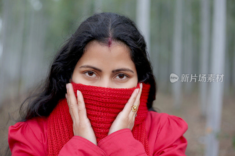 年轻的印度妇女用围巾遮住自己的脸