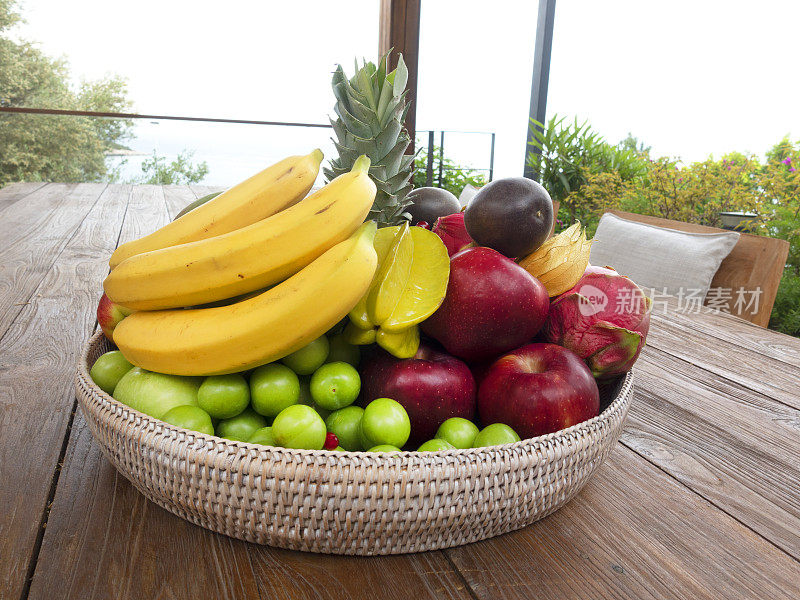 新鲜的夏季水果与柳条篮子在木桌子上。