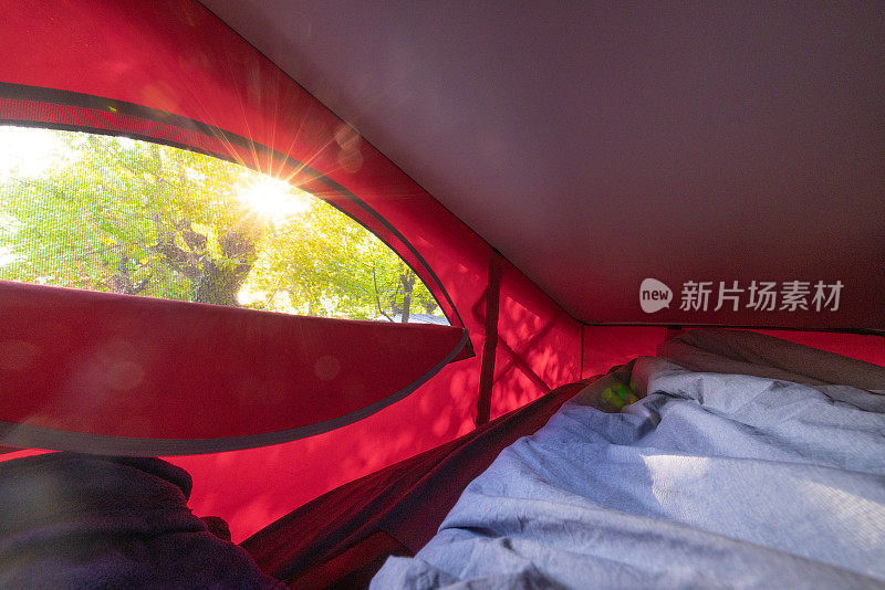 在露营车的帐篷内，阳光透过树照进来
