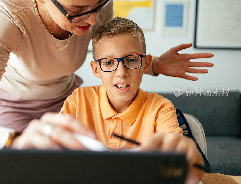 一位匿名母亲在家用平板电脑帮儿子上新课