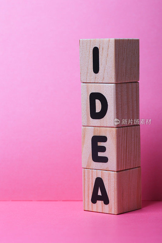 IDEA词在木制立方体上的粉红色背景