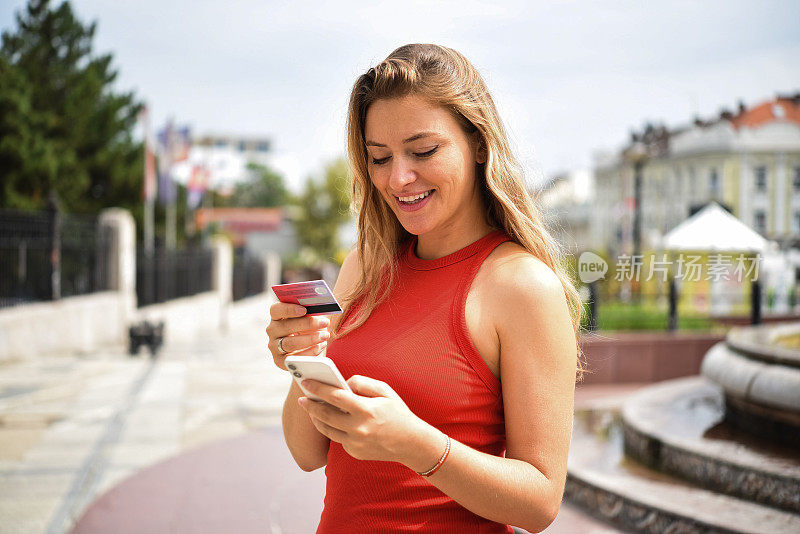 一个快乐的年轻女子享受网上购物的肖像