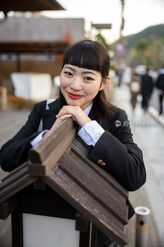 快乐的高中女孩在街上靠在招牌上