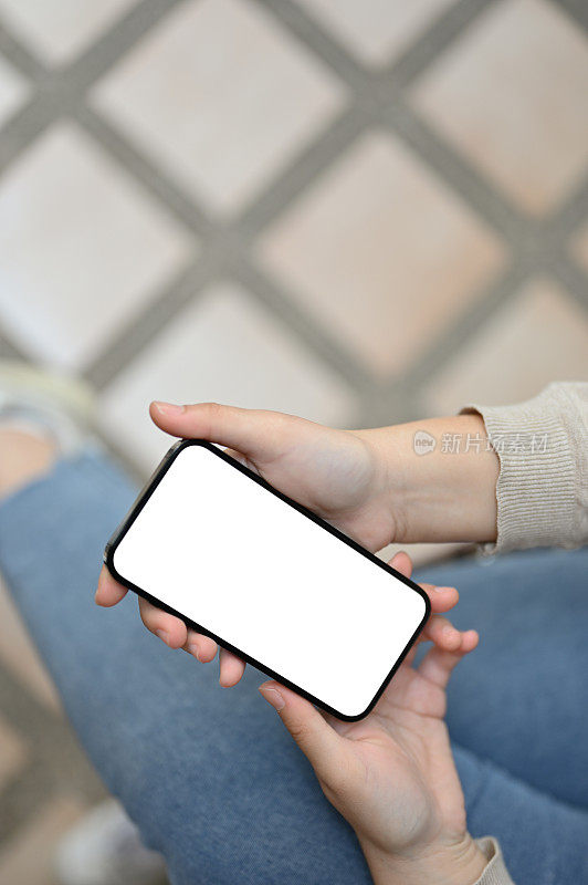 一名女性使用智能手机的特写图像，手机白屏模型。