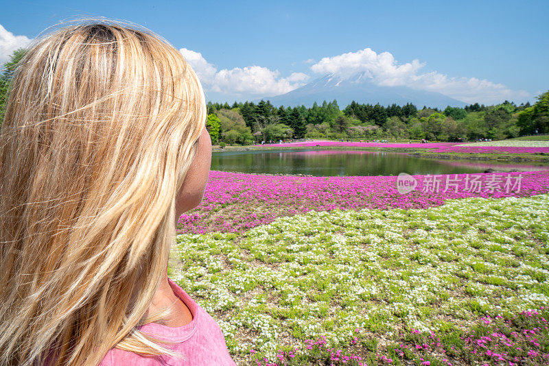 一名女子在日本旅行，凝视着富士山的美景