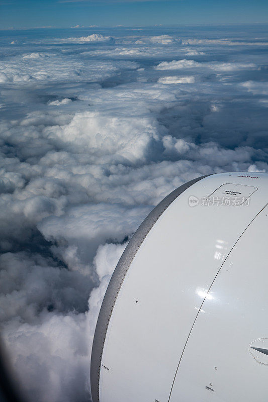 商用飞机喷气发动机。从船舱的窗户看，蓝天，下面是阴云，没有人