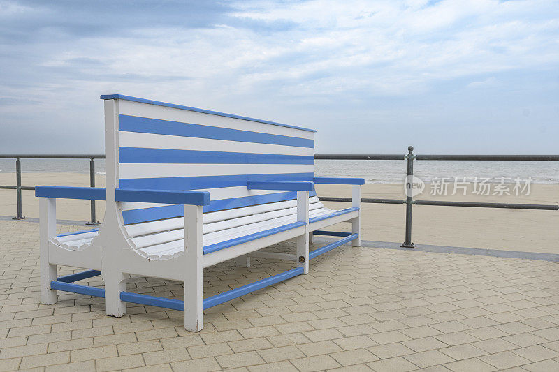 海滨地区靠近海边的长椅，供游客放松。海风吹来，空出文字