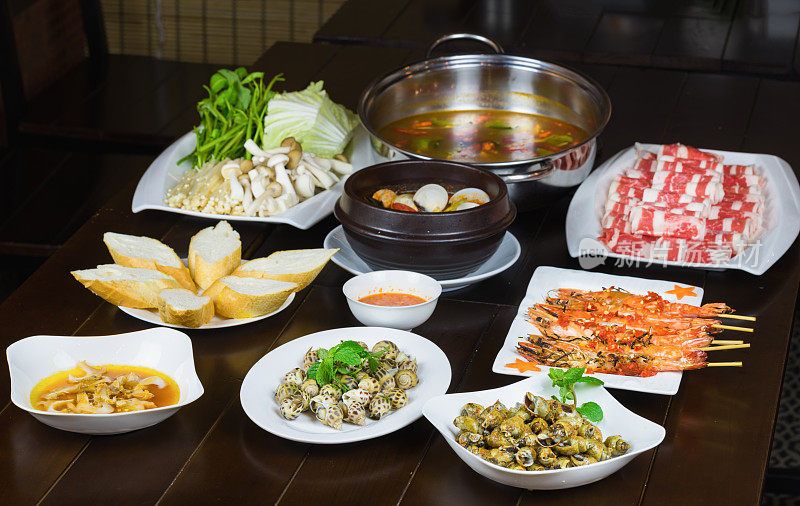 一套越南海鲜配烧烤虎虾，烤甜蜗牛，面包片，辣蒸蛤，蔬菜和生牛肉片火锅