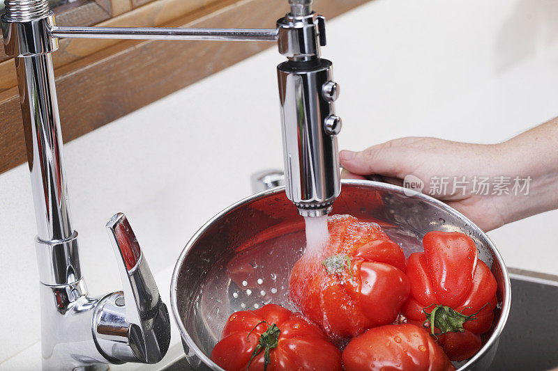 用滤锅清洗西红柿。