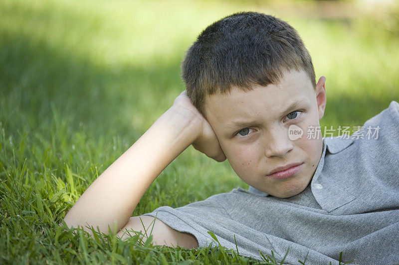 草地上一个忧郁的男孩的肖像