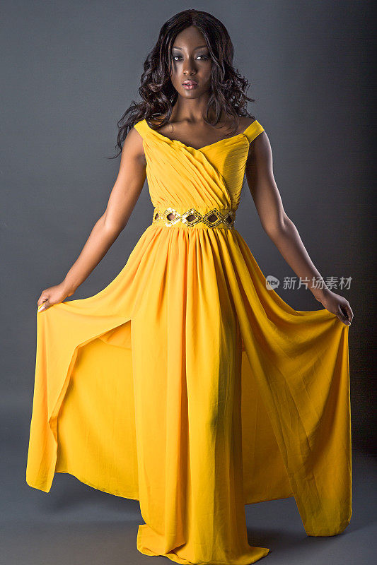 穿着黄色长袍的漂亮时装模特