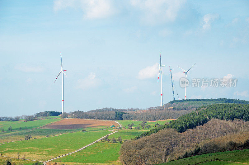 风力涡轮机与起重机在丘陵景观