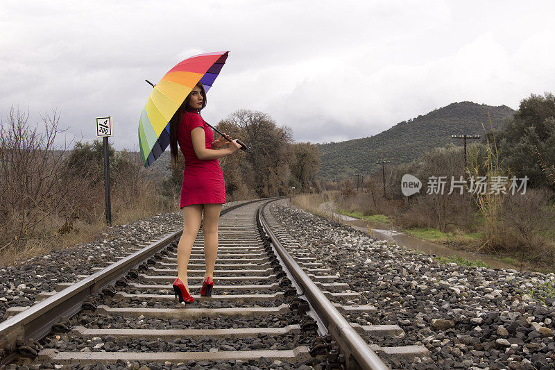 穿红色衣服的女人在铁轨上行走