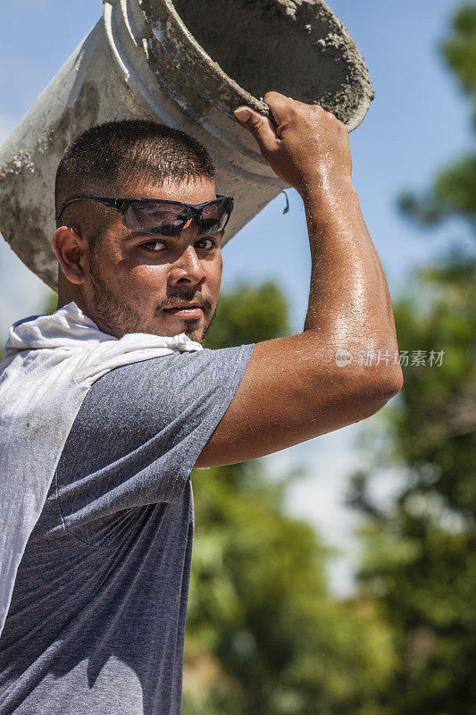 西班牙建筑工人搬运水泥桶