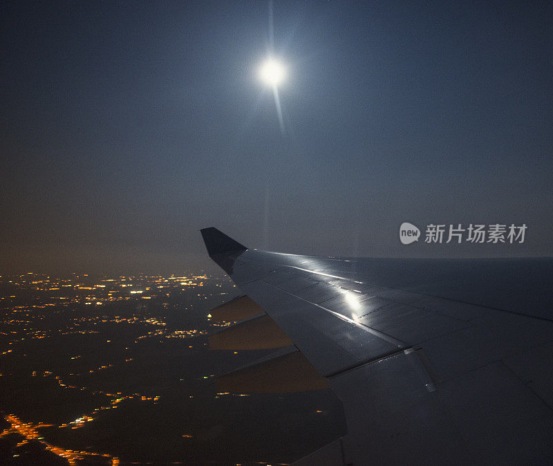 夜晚，飞机机翼上的月亮