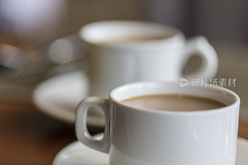 特写两杯加牛奶或奶油的咖啡。