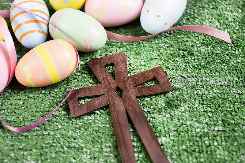 草地上有木制十字架的复活节彩蛋。