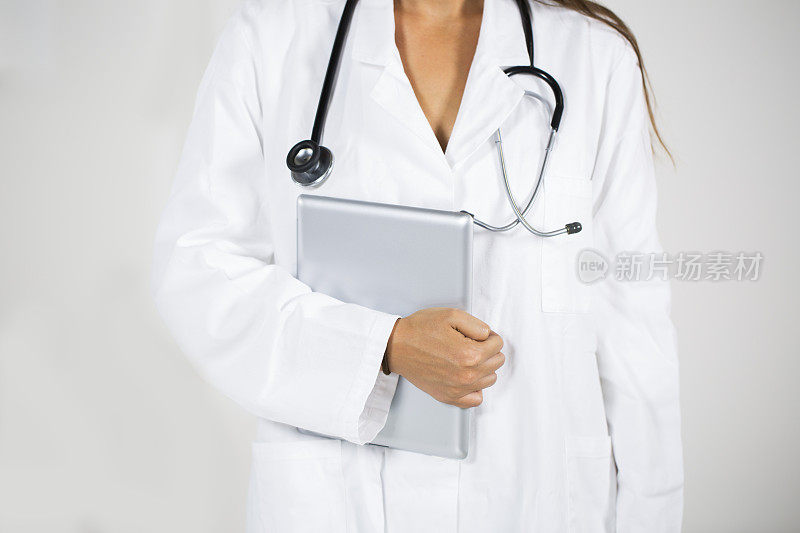 年轻女医生的躯干与数字平板电脑和听诊器
