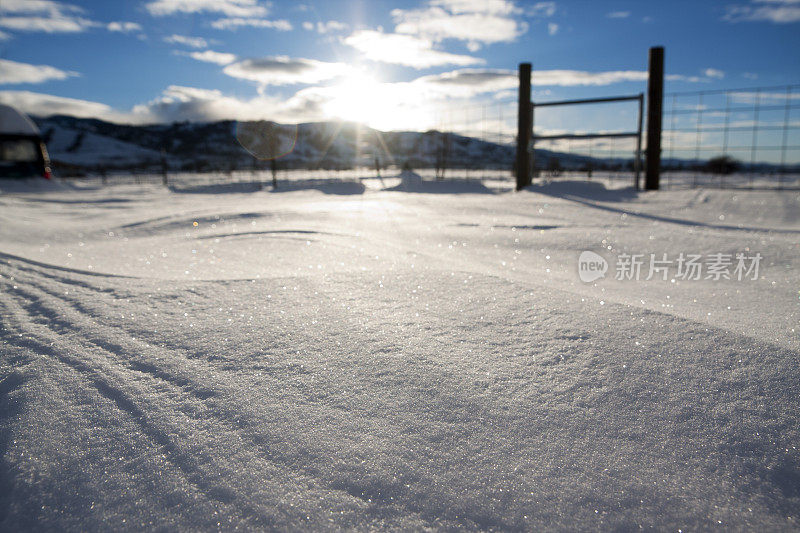 雪的特写与栅栏和山脉