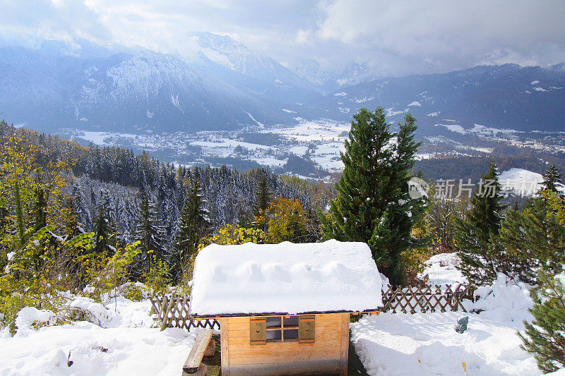 乡村谷仓下的雪和瓦克森斯坦巴伐利亚阿尔卑斯山，田园诗般的松树林地下的雪景观，雄伟的阿尔卑斯山山谷，戏剧性的巴伐利亚德国雪山全景，贝希特斯加登阿尔卑斯山，德国