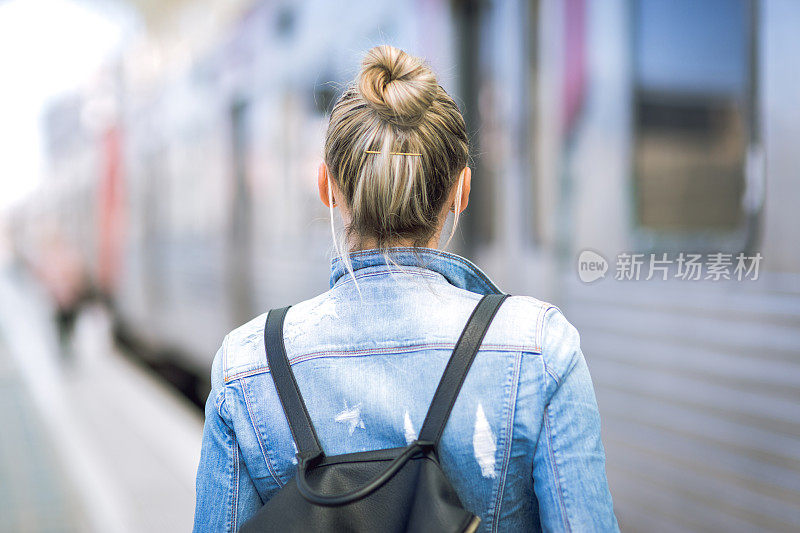 女子旅行者背包在火车站检查时间