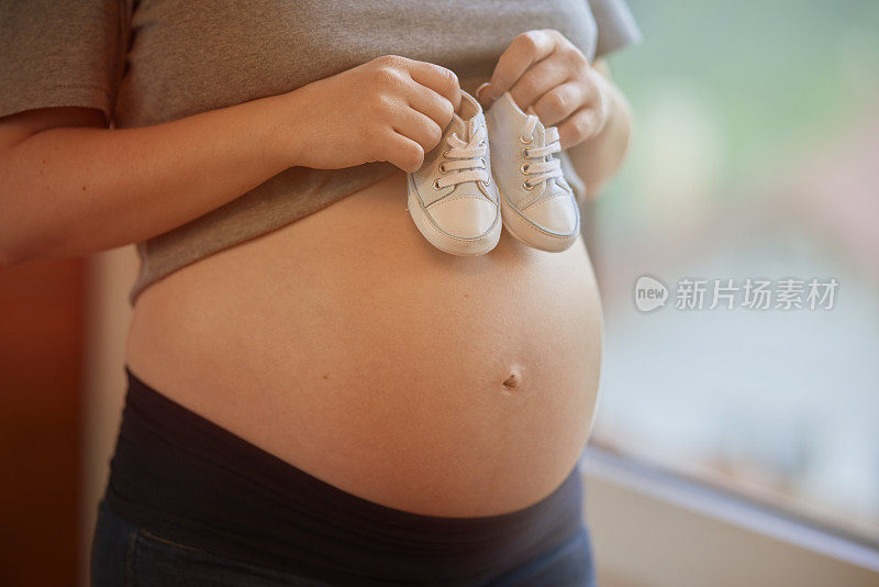 怀孕的肚子和婴儿鞋