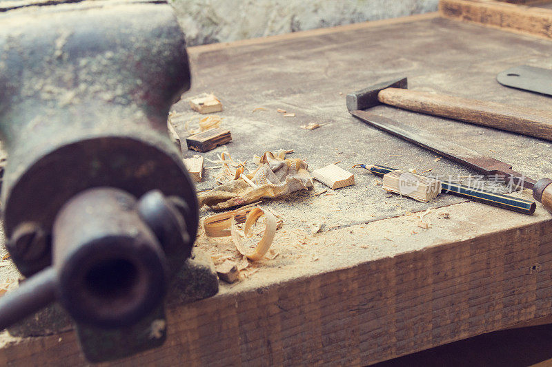 木匠的小工具放在积满灰尘的桌子上。