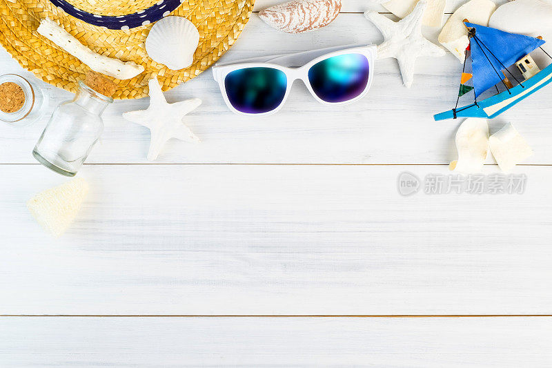 夏日沙滩配饰(白色太阳镜，海星，草帽，玻璃瓶，贝壳)上白色石膏木桌顶视图，夏日度假概念，留出空间添加文字。