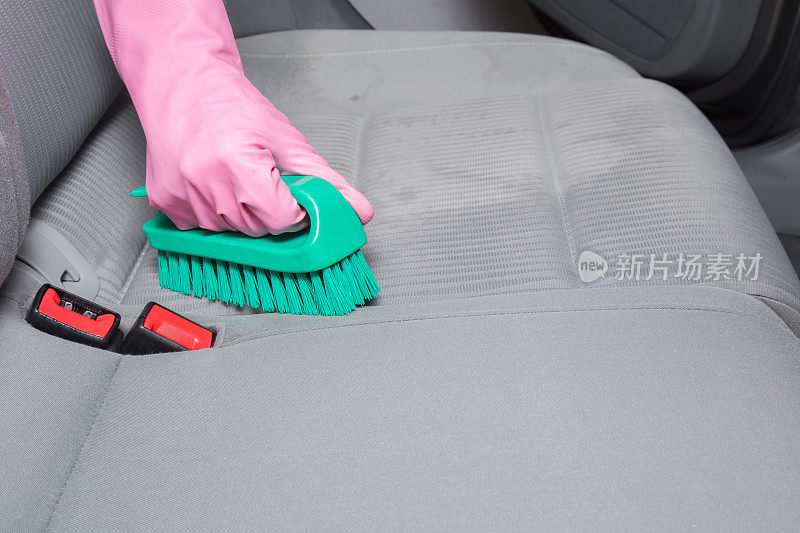 刷在汽车内部的纺织品座椅。早春大扫除或定期大扫除。专业化学清洗。