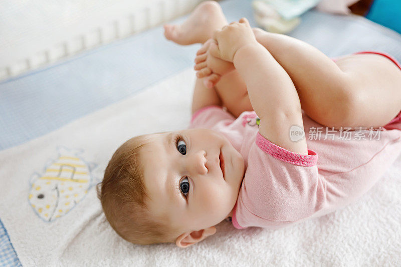 可爱的宝宝用嘴叼着脚。可爱的小女孩吮着脚。