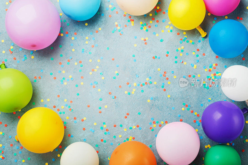 彩色气球和五彩纸屑在绿松石桌顶视图。生日、假日或聚会背景。平的风格。