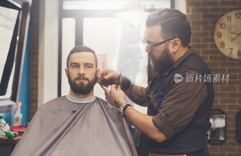 理发师在理发店里给一个男人理发