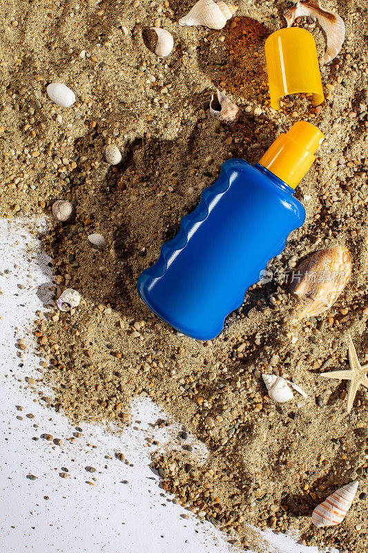 瓶装防晒喷雾喷在沙滩上