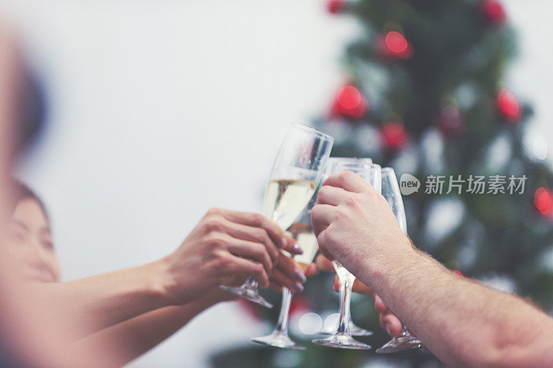 一群人用香槟和圣诞树敬酒。
