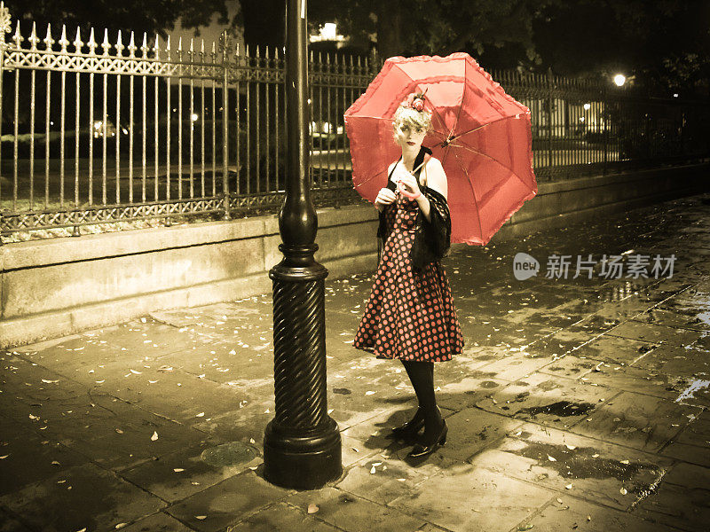 金色复古风格哥特式女子在路灯下手持红色雨伞