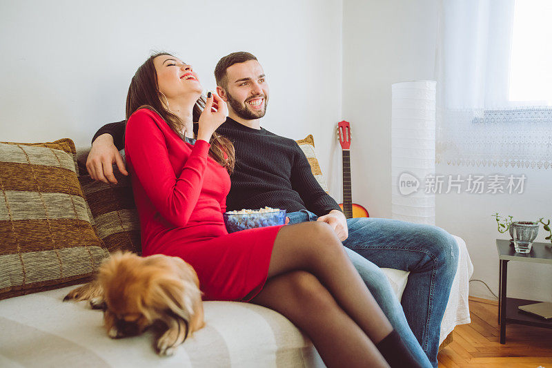 年轻夫妇在家里看电视