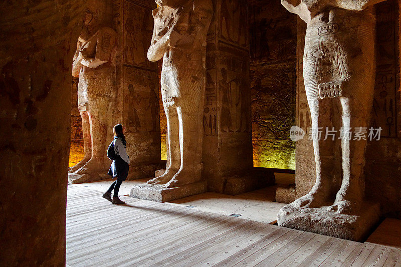 年轻的千禧一代游客在阿布辛贝的拉美西斯二世神庙内的巨大雕像之间看起来很小