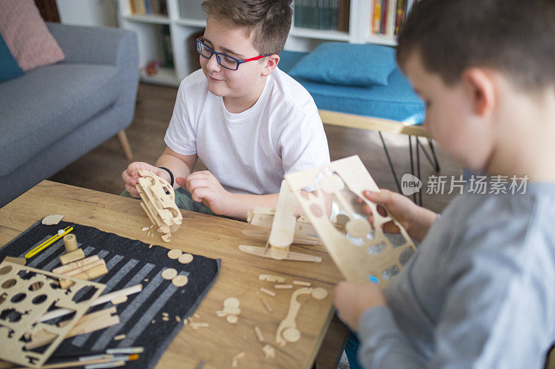 兄弟们正在为学校项目制作木制模型飞机