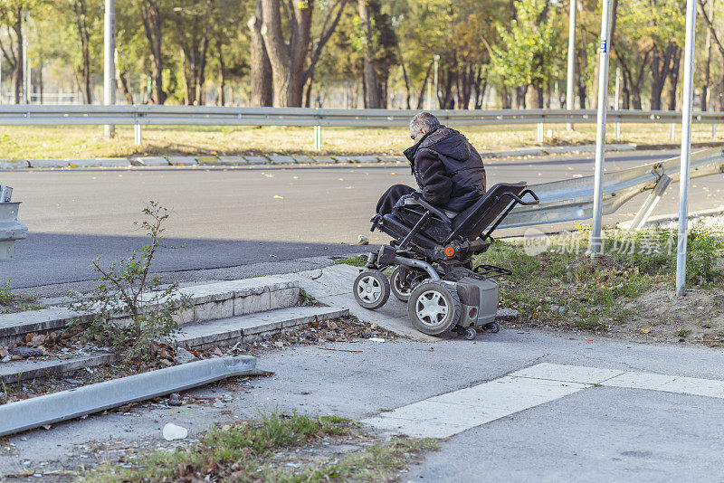 坐在电椅上的残疾人正在避开路上的障碍物