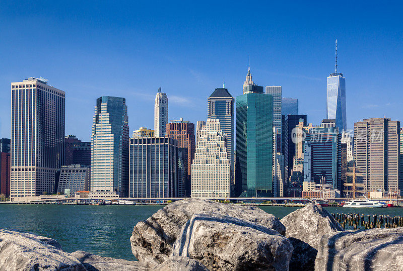 纽约城市天际线与曼哈顿金融区，世界贸易中心，东河和岩石在前景，纽约，美国。