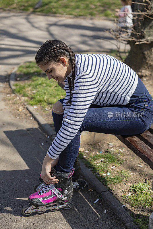 一个十几岁的女孩正在准备她在公园里的溜冰溜冰场