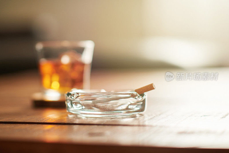 咖啡桌上有酒，还有香烟和烟灰缸