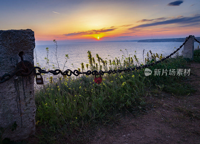 夕阳和漆红的挂锁上的链条