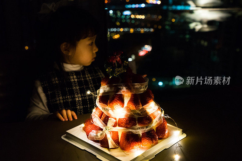 一个小女孩拿着生日蛋糕