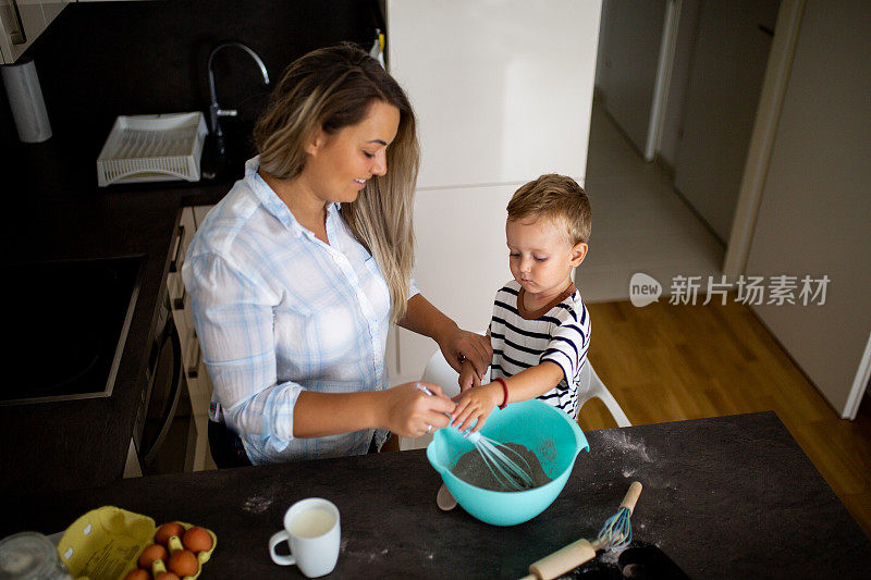 年轻漂亮的母亲和她的小儿子一起烤饼干