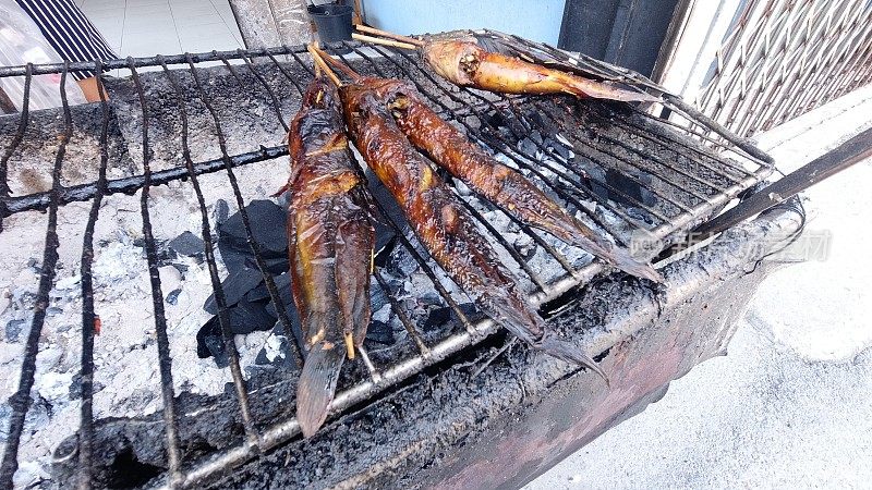 坑和炉子上烤鲶鱼