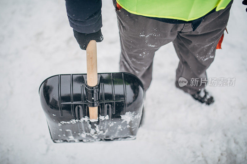 拿着雪铲的男人