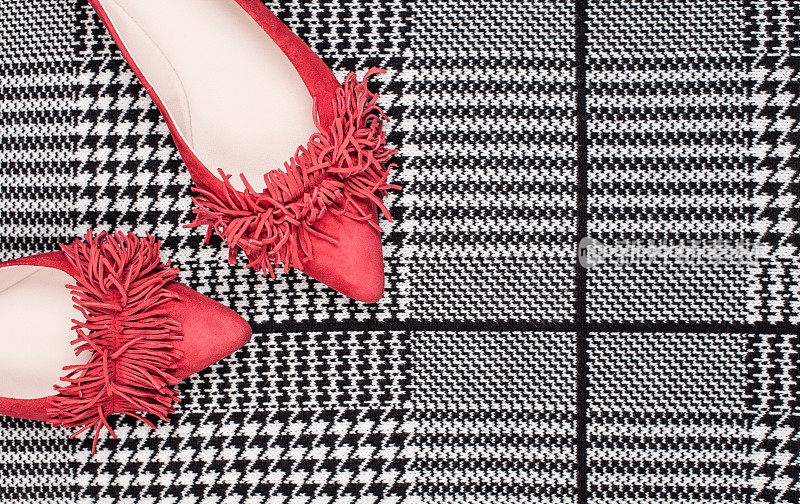 平铺的红色女鞋上的黑色和白色格子图案